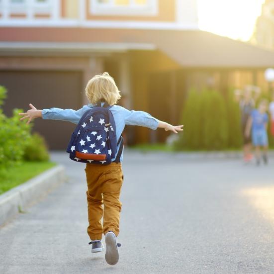 Yngre dreng med ryggen til med rygsæk på